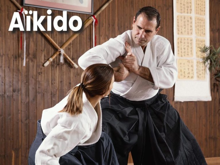 Aïkido Pratique de l'aïkido avec un homme et une femme en tenue traditionnelle.